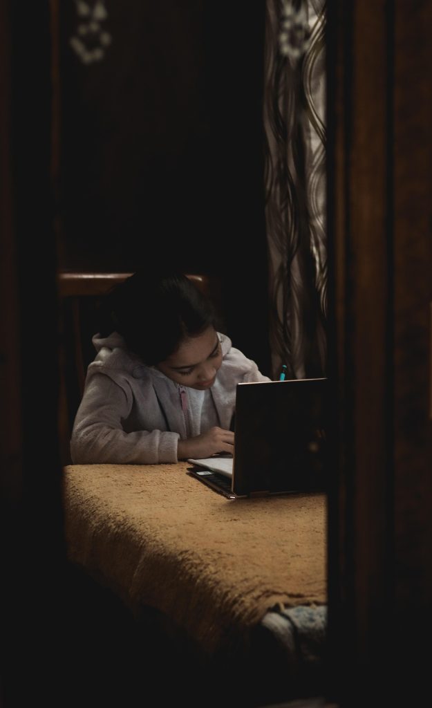 Girl writing next to a laptop